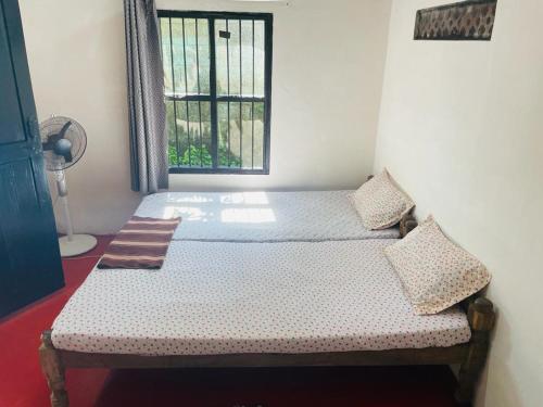 a bedroom with two beds and a window at The Blues in Alleppey