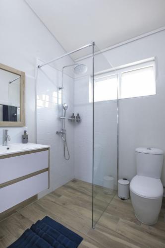 a bathroom with a toilet and a glass shower at AMIS Apartments by Host Agents in Bain Boeuf