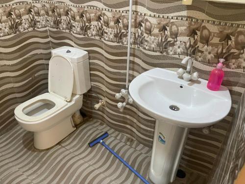 a bathroom with a toilet and a sink at Rayyan Beach House in Karachi