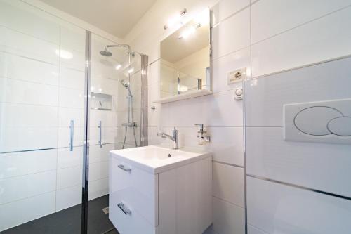 a white bathroom with a sink and a shower at Spacious modern One bedroom Apartment with Garden & SeaView in Rab