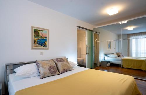 a bedroom with a large bed with a yellow blanket at Spacious modern One bedroom Apartment with Garden & SeaView in Rab