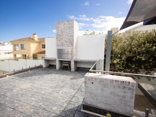 a patio with a white wall and a building at Yzerfontein Beach Accommodation in Yzerfontein