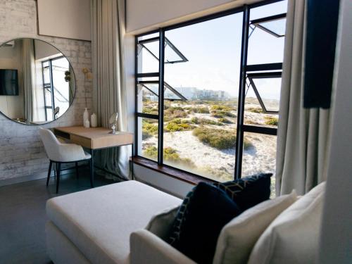 ein Zimmer mit einem Sofa und einem großen Fenster in der Unterkunft Yzerfontein Beach Accommodation in Yzerfontein