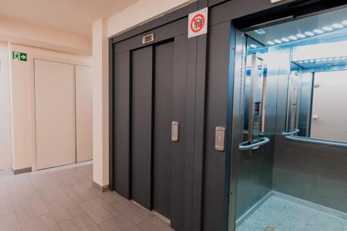 an elevator in a building with a glass door at Pierre & Vacances La Merceria in El Tarter