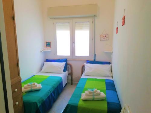2 Betten in einem Zimmer mit Handtüchern darauf in der Unterkunft Gambusia in Scoglitti