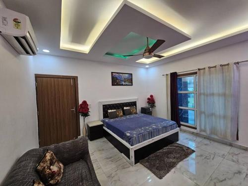 a bedroom with a bed and a couch at Moksha Farm, 3BHK Luxury Farm Stay, 7000 sq ft in Noida