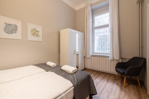 um quarto com uma cama, uma cadeira e uma janela em BpR Castle Hill Apartment with Garden em Budapeste