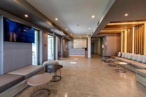 a waiting area in a hospital with tables and chairs at White Olive Premium Lindos in Pefki Rhodes