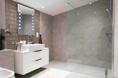 a bathroom with a shower and a sink and a mirror at Sirius in Simonsberg