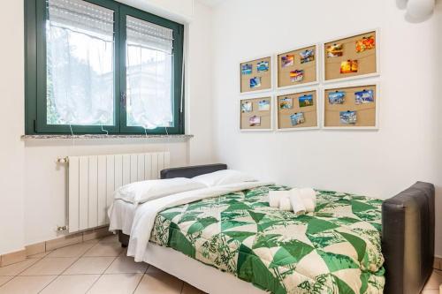 een slaapkamer met een bed met een groene en witte quilt bij Accogliente Bilocale con Giardino e Parcheggio in Monza