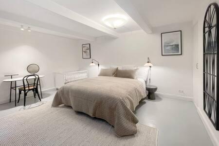 a white bedroom with a bed and a desk at 2BR Apartment in Heart of CPH City in Copenhagen