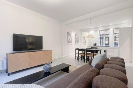 a living room with a couch and a flat screen tv at 2BR Apartment in Heart of CPH City in Copenhagen