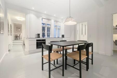a white kitchen with a table and chairs in it at 2BR Apartment in Heart of CPH City in Copenhagen