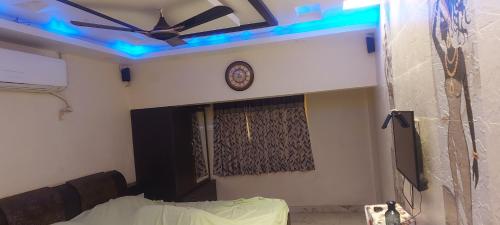 um quarto com uma ventoinha de tecto e luzes azuis em Varsha residency em Puri