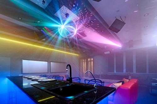 Zimmer mit einer Bar mit lila und blauen Lichtern in der Unterkunft Новые уютные апартаменты у моря in Odessa