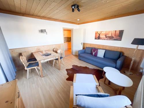 ein Wohnzimmer mit einem blauen Sofa und einem Tisch in der Unterkunft Hotel Residence Metropol in Seefeld in Tirol