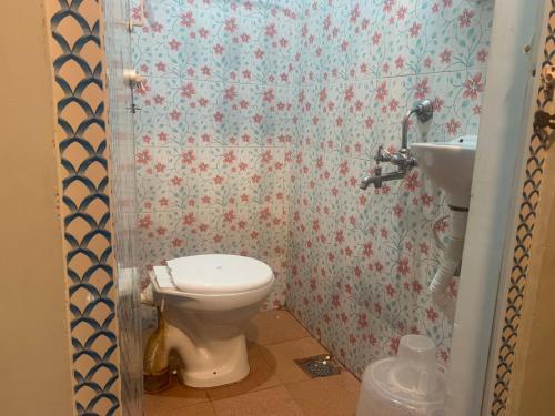 a bathroom with a toilet and a sink at Hotel Sikara, Kumbakonam in Kumbakonam