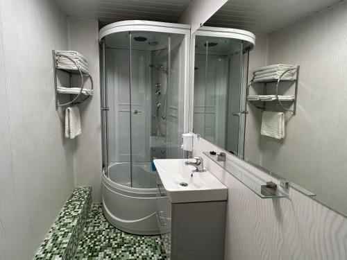 a bathroom with a shower and a sink and a mirror at A1 apartments with free parking in Rīga