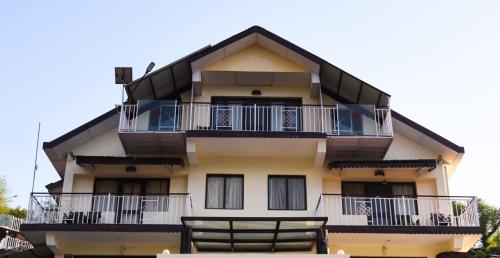 a tall yellow building with balconies at Dragon I Resorts in McLeod Ganj
