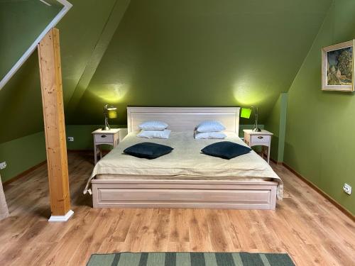 a bedroom with a bed with green walls and two tables at A1 apartments with free parking in Rīga