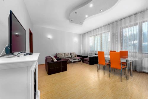 a living room with a dining table and orange chairs at Central Apartament Predeal Nr 4 in Predeal