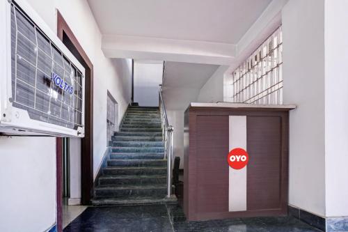 a hallway with stairs and a door with a stop sign at OYO Flagship Sanskar Garden in Rānchī
