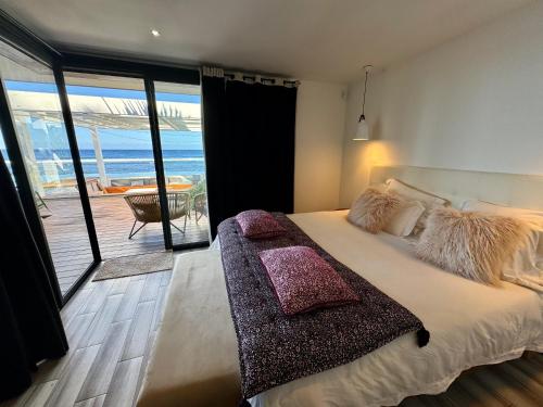 Un dormitorio con una cama con vista al mar. en Villa Paradis Piscine et jacuzzi bord de mer, en Trois Bassins