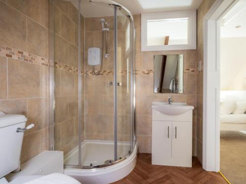 een badkamer met een douche, een toilet en een wastafel bij 5 Bed in Aberystwyth 58889 in Llanrhystyd