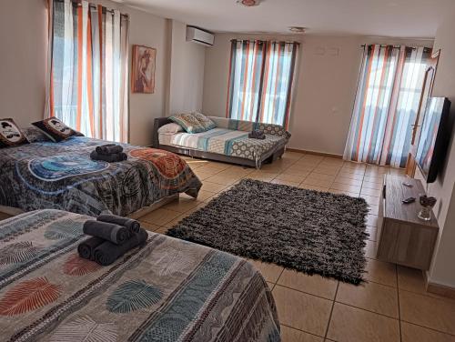 une chambre d'hôtel avec deux lits et un canapé dans l'établissement CASA CLIMATIZADA VACACIONAL, à Villalonga