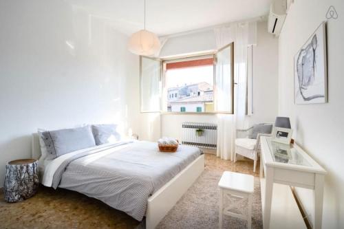 a white bedroom with a bed and a desk and a window at Casa Vacanze Via Marconi in Marotta