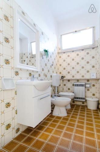 a bathroom with a toilet and a sink and a mirror at Casa Vacanze Via Marconi in Marotta