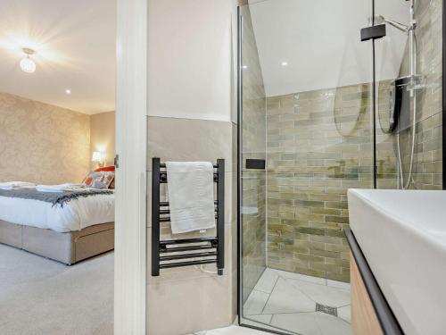 uma casa de banho com um chuveiro, um lavatório e uma cama em 2 Bed in Ennerdale 93196 em Ennerdale Bridge