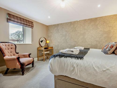 um quarto com uma cama, uma cadeira e um espelho em 2 Bed in Ennerdale 93196 em Ennerdale Bridge
