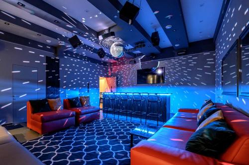 Zimmer mit Sofas und einer Bar mit blauen Lichtern in der Unterkunft Новые уютные апартаменты у моря in Odessa