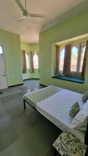 - une chambre avec un grand lit et 2 fenêtres dans l'établissement The Aawargarh Retreat, à Jharol