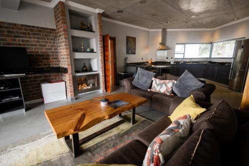 ein Wohnzimmer mit einem Sofa und einem Tisch in der Unterkunft Yzerfontein Beach Accommodation in Yzerfontein