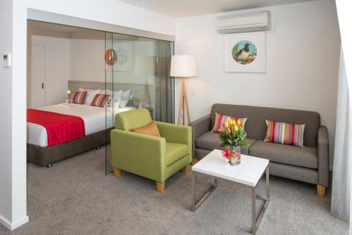 um quarto de hotel com uma cama, um sofá e uma cadeira em Quest Nelson em Nelson