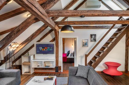 4 Arts Apartments by Adrez في براغ: غرفة معيشة مع عوارض خشبية