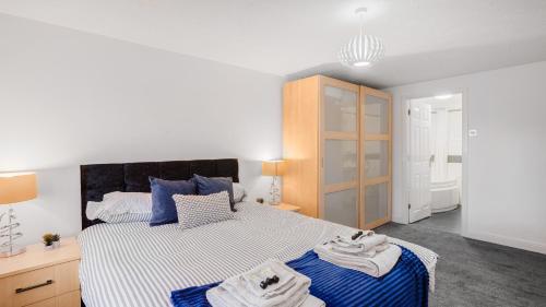 a bedroom with a large bed with towels on it at The Lodge - Exquisite 2 Bed with Ensuite in Birmingham