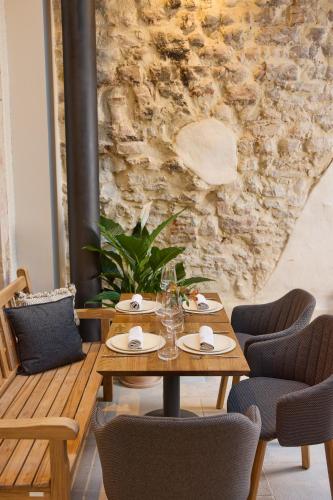 a table and chairs in a room with a stone wall at Maison 1896 in Beaune