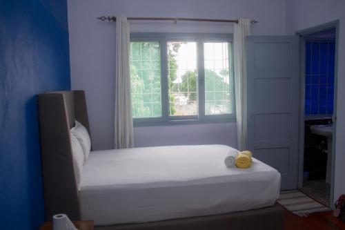 a white bed in a room with a window at Platina House in Maputo