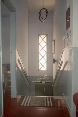 einen Flur mit einem Tisch und einem Fenster in der Unterkunft Platina House in Maputo