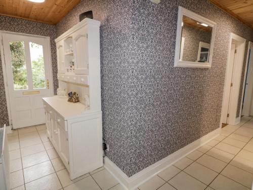 La salle de bains est pourvue d'un lavabo et d'un miroir mural. dans l'établissement Gortin Cottage, à Ballymena