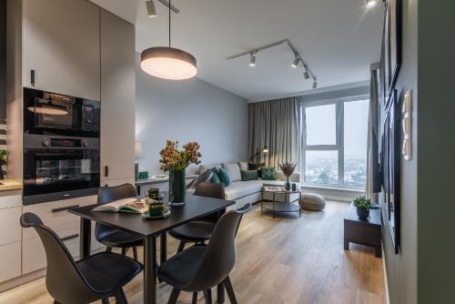 a kitchen and living room with a table and chairs at Emihouse KrakoVska Apartments in Rzeszów