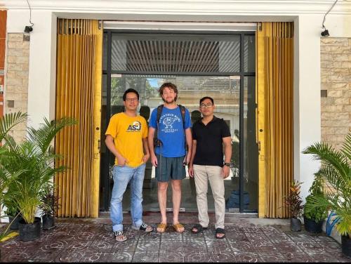 a group of three men standing in front of a door at Whitehouse Guesthouse in Phnom Penh