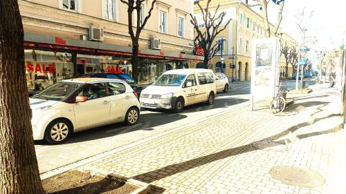 zwei Autos stehen auf einer Stadtstraße. in der Unterkunft Townhouse CityCentre in Klagenfurt am Wörthersee