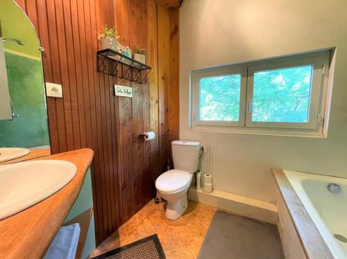 La salle de bains est pourvue de toilettes, d'un lavabo et d'une baignoire. dans l'établissement Logement à Toulouse dans un écrin de verdure, à Toulouse