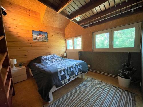 a bedroom with a bed in a wooden cabin at Logement à Toulouse dans un écrin de verdure in Toulouse