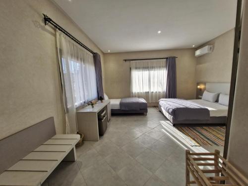 a hotel room with two beds and a window at Le Parc des Oliviers in Marrakech