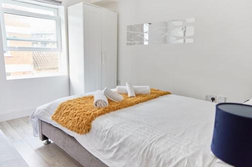 a white bedroom with a bed with towels on it at *7 La dolce vita in Brick Lane in London